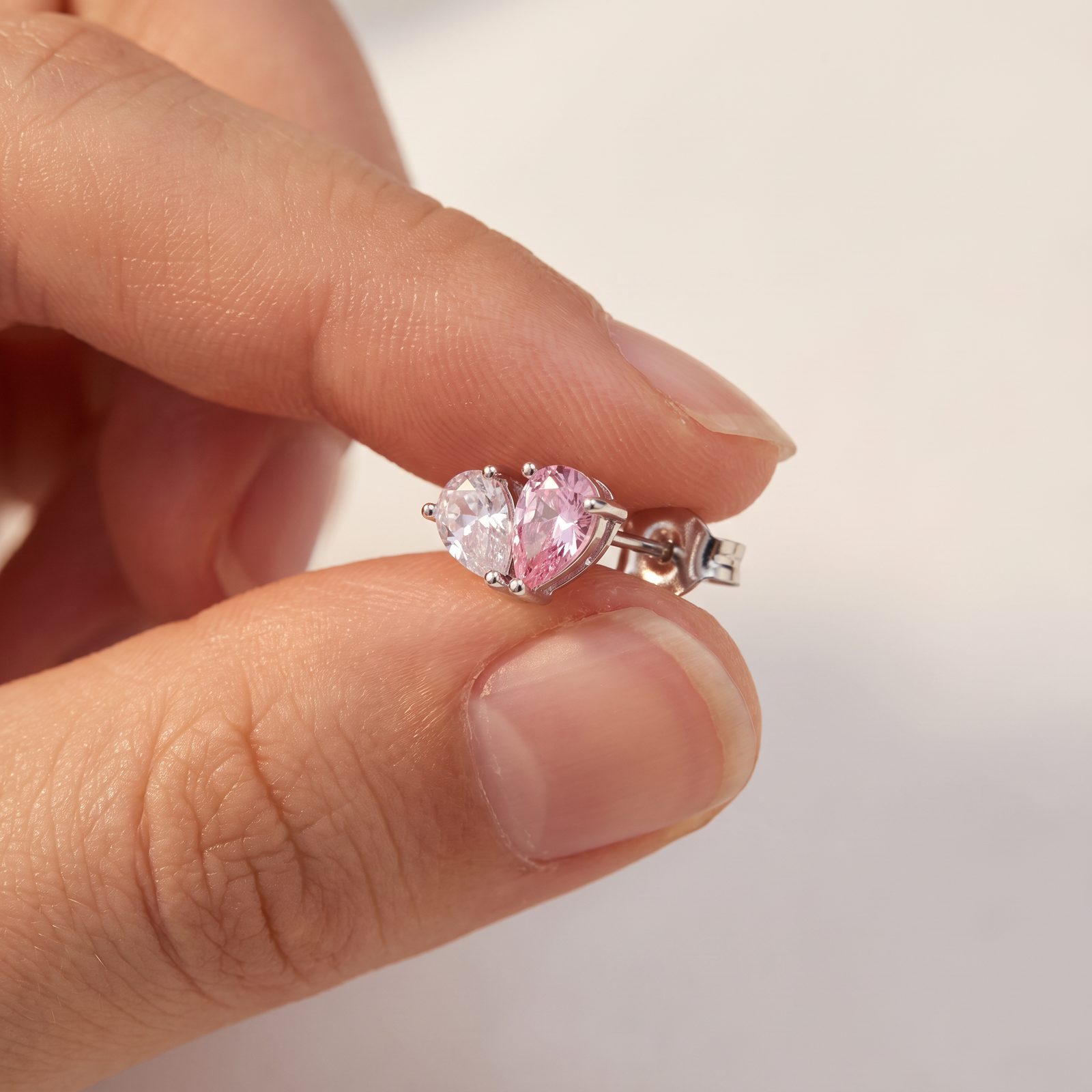 Minđuša srce među prstima — široka 13,4 mm, otprilike kao nokat